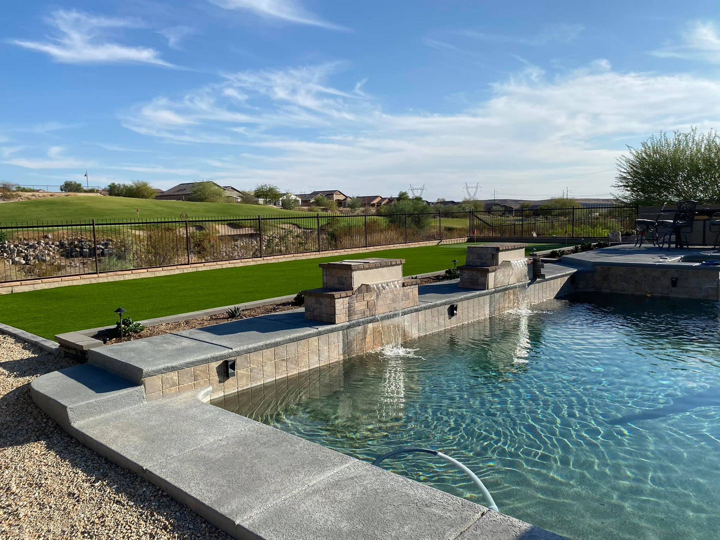 Custom pool with water feature and turf surround